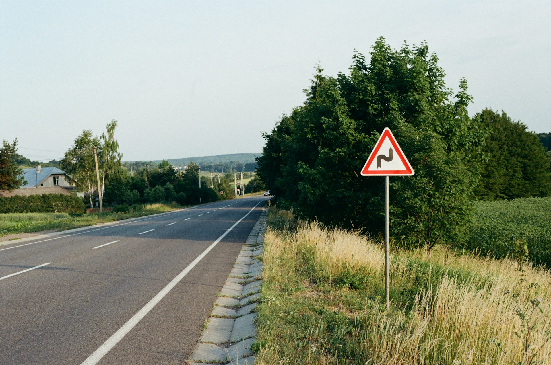 a red and white sign sitting on the side of a road